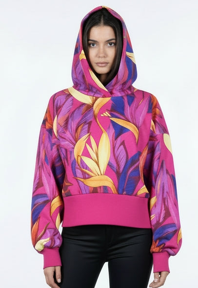 Modella in primo piano indossa FELPA con cappuccio ADIDAS per FARM RIO colore floreale su base fucsia modello COD JD6283 