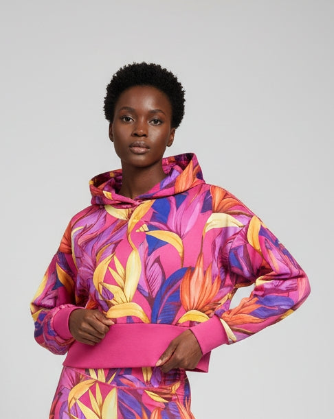Modella indossa FELPA con cappuccio ADIDAS per FARM RIO colore floreale multicolore su base fucsia modello COD JD6283 
