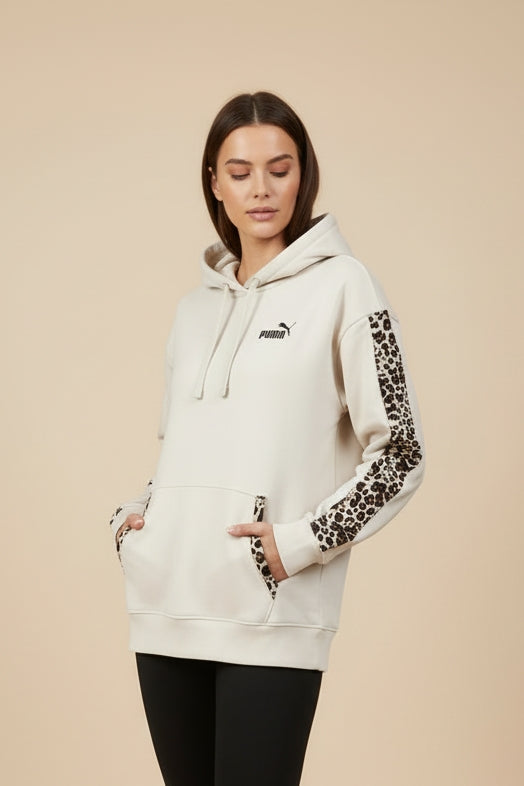 Modella indossa FELPA PUMA DONNA 688084 BEIGE con mani in tasca per mostrare dettagli animalier su maniche e cuciture nelle tasche a marsupio 