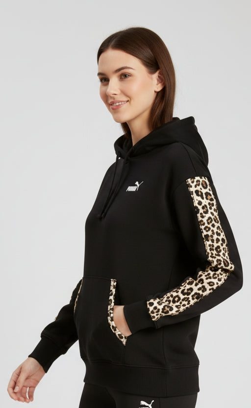 Modella indossa FELPA PUMA DONNA 688084 nera con mano in tasca per mostrare dettagli animalier su maniche cuciture tasche frontale 