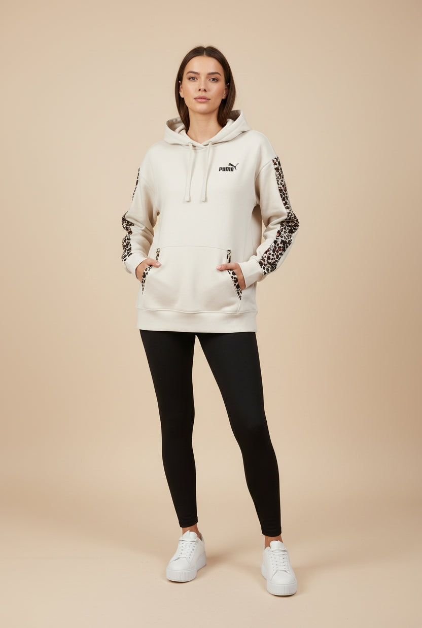 Modella indossa FELPA PUMA DONNA 688084 BEIGE con mani in tasca per mostrare dettagli animalier su vista frontale 